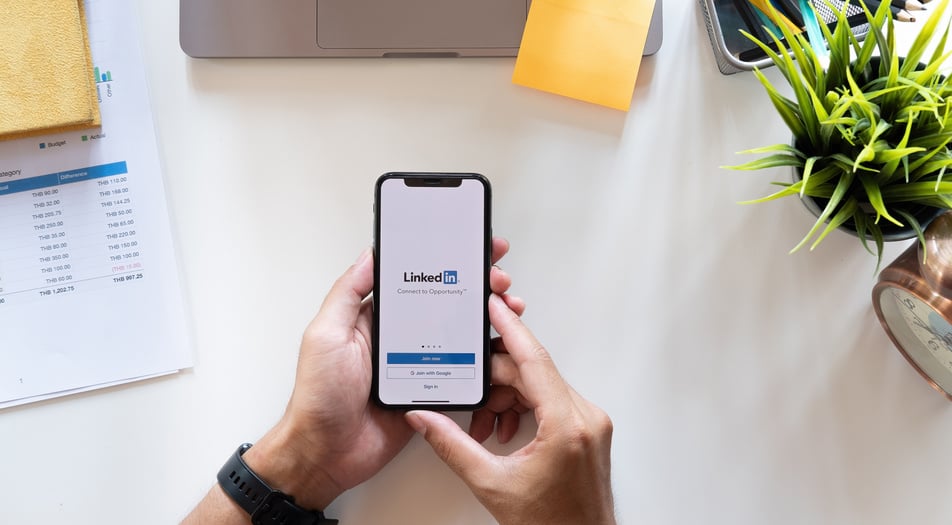 Person Holding Smartphone with LinkedIn on Screen 